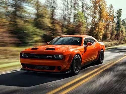 2023 Dodge Challenger driving on a road surrounded by trees