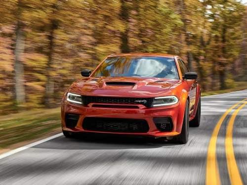 2023 Dodge Charger driving fast on a road surrounded by trees